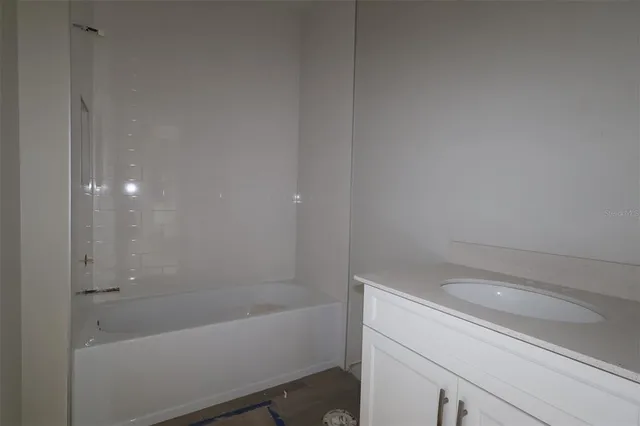 a bathroom with a granite countertop sink a toilet and shower