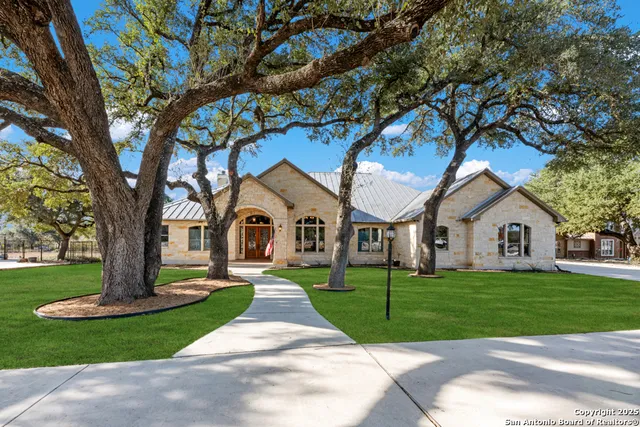 a front view of a house with a yard and trees