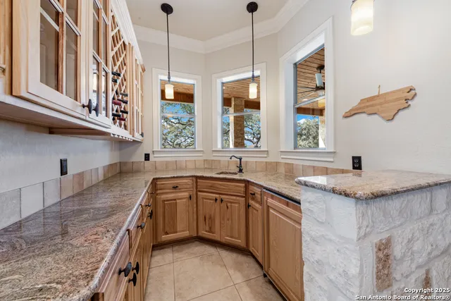 a kitchen with stainless steel appliances granite countertop a sink a stove and a wooden cabinets