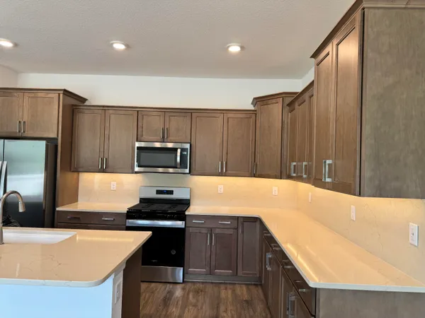 a kitchen with kitchen island a counter top space cabinets and stainless steel appliances