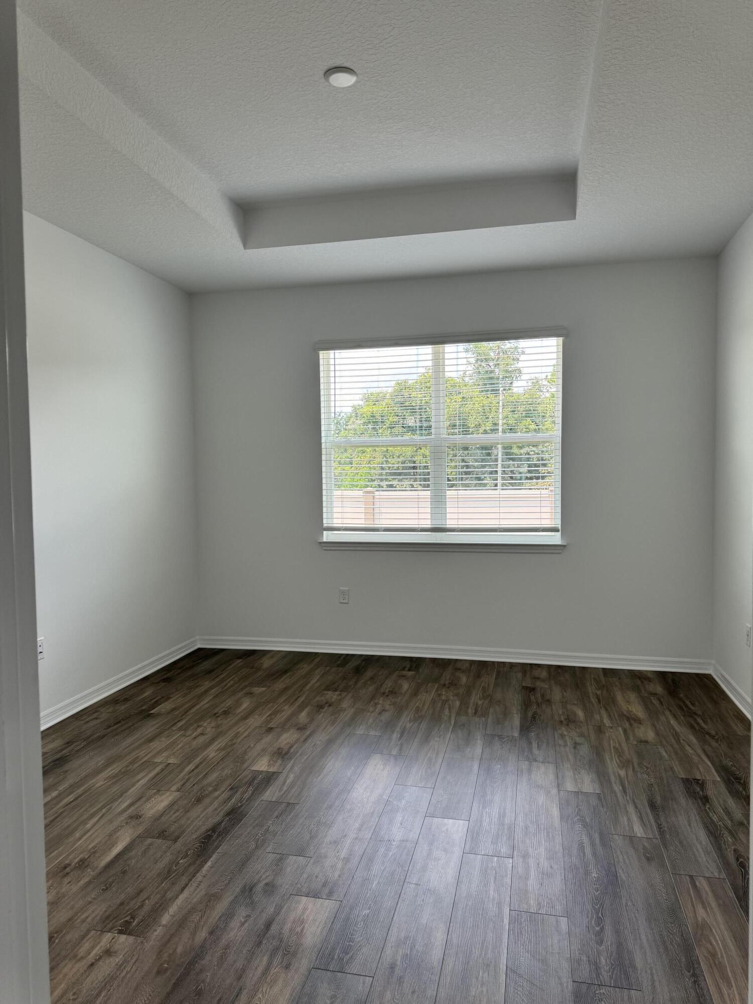 5662 Southwest 78th Ave Road Ocala, FL 34474 - Photo 3 of 15 an empty room with wooden floor and windows