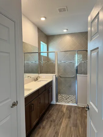a bathroom with a granite countertop sink a mirror and a shower