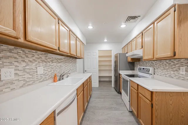 a kitchen with stainless steel appliances a sink a stove and a refrigerator