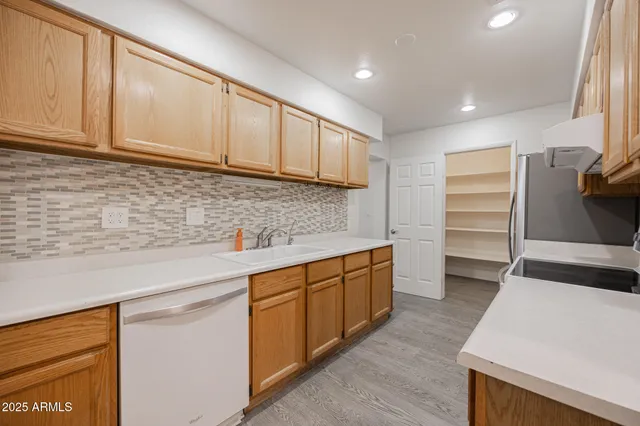 a kitchen with white cabinets and sink