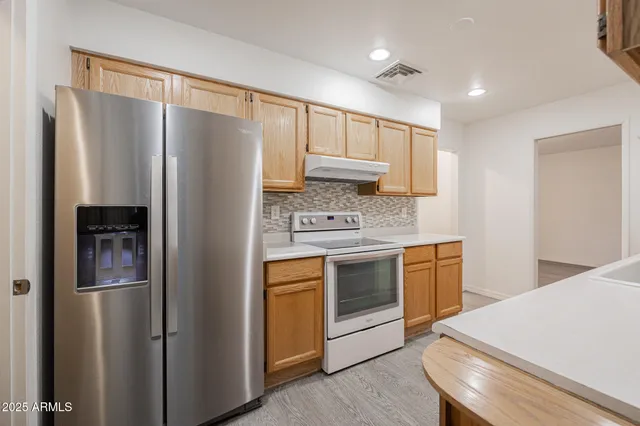 a kitchen with stainless steel appliances granite countertop a refrigerator stove and sink
