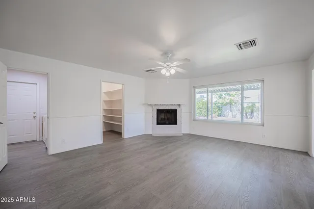 an empty room with windows and fireplace