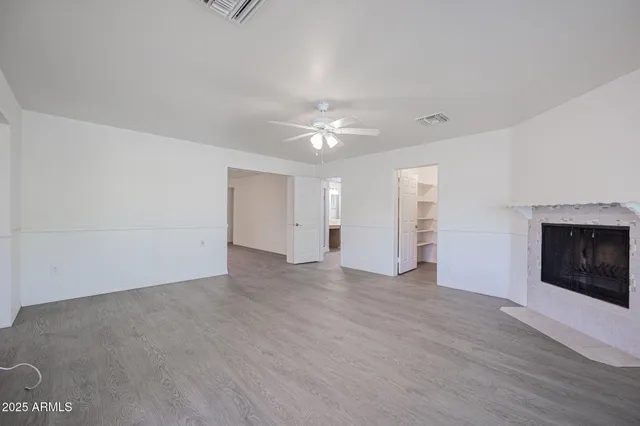 a view of an empty room with a fireplace and a window
