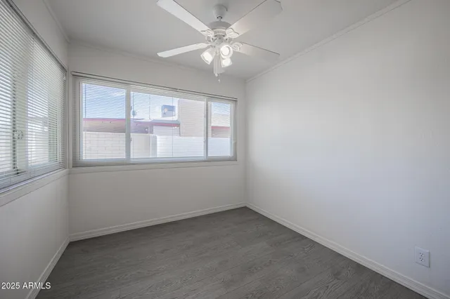 an empty room with a window and a fan