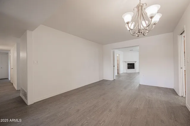 a view of empty room with wooden floor and window