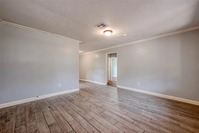 a view of an empty room with wooden floor