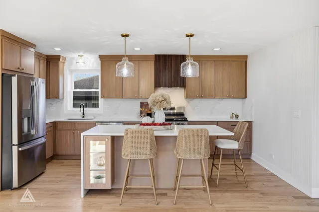 a kitchen with a dining table chairs refrigerator and microwave