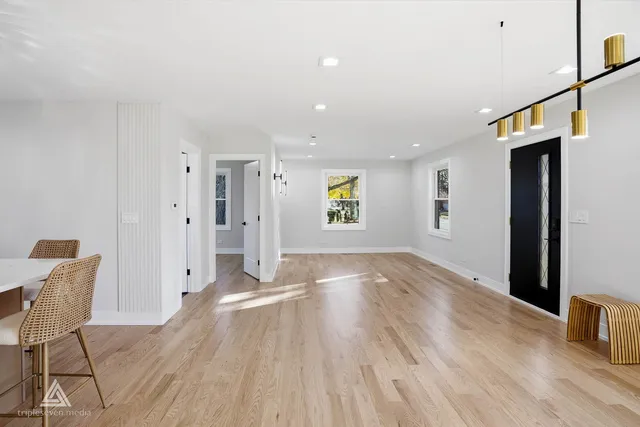 a view of a big room with wooden floor and windows
