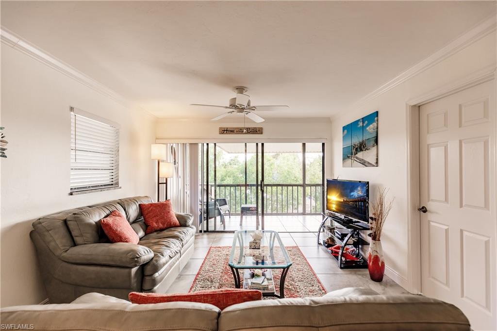 a living room with furniture a flat screen tv and a large window