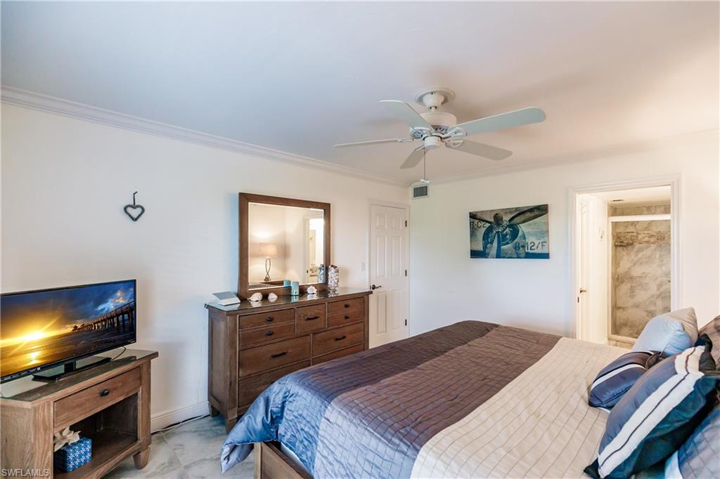 600 Neapolitan Way, Unit 454 Naples, FL 34103 - Photo 13 of 26 a bedroom with a bed and a flat screen tv