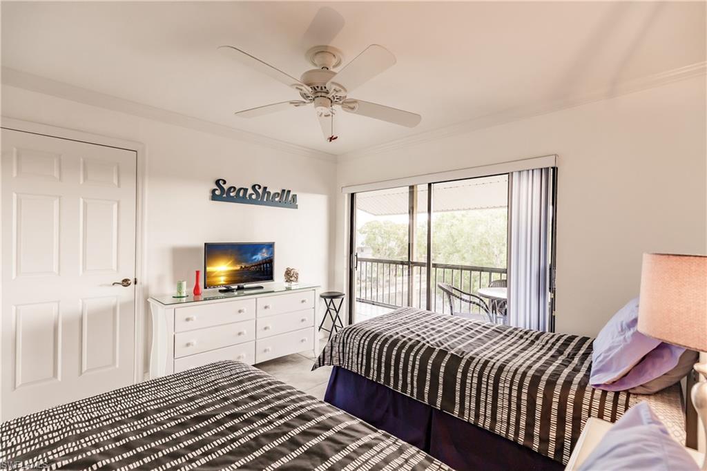 600 Neapolitan Way, Unit 454 Naples, FL 34103 - Photo 17 of 26 a spacious bedroom with a bed and a flat screen tv