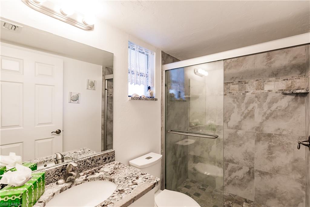 600 Neapolitan Way, Unit 454 Naples, FL 34103 - Photo 18 of 26 a bathroom with a sink toilet and shower