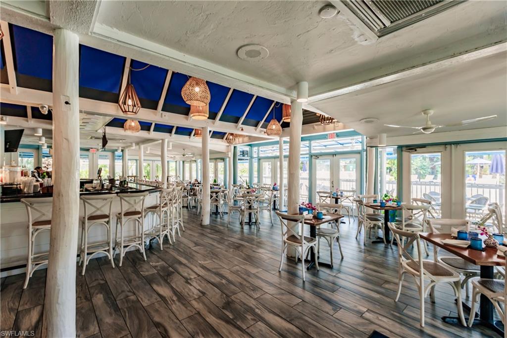 600 Neapolitan Way, Unit 454 Naples, FL 34103 - Photo 24 of 26 a view of a dining room with furniture window and wooden floor