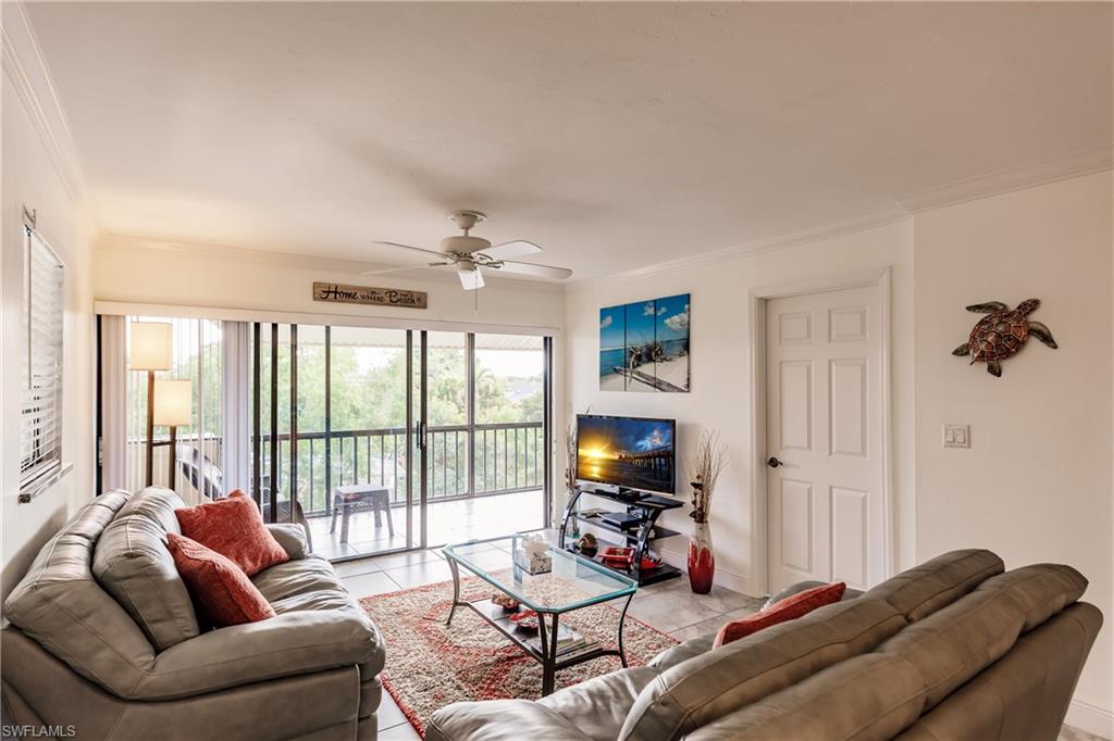 600 Neapolitan Way, Unit 454 Naples, FL 34103 - Photo 3 of 26 a living room with furniture a flat screen tv and a large window