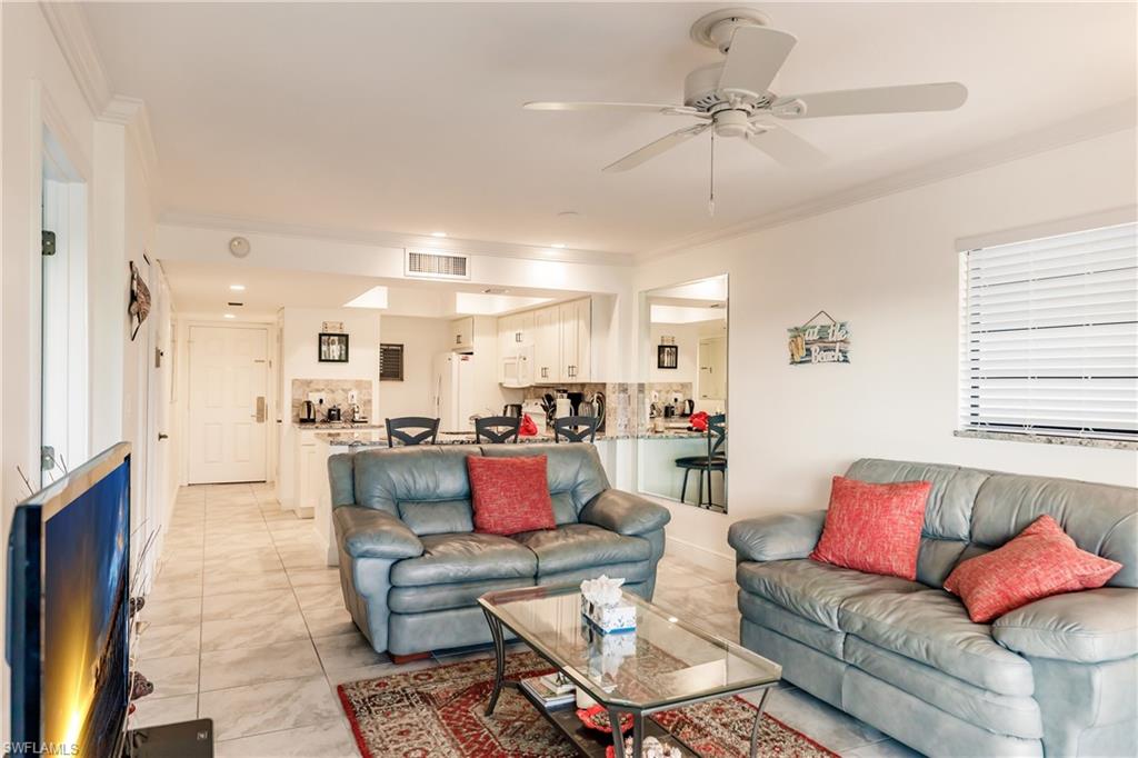 600 Neapolitan Way, Unit 454 Naples, FL 34103 - Photo 6 of 26 a living room with furniture and a chandelier