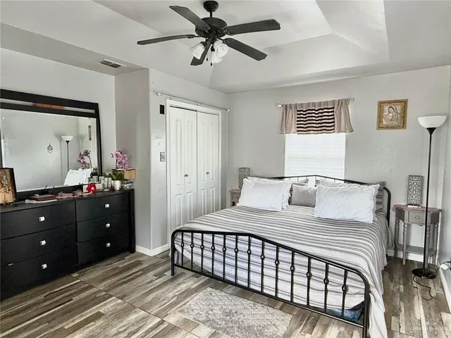 a bedroom with a bed and a mirror on a dresser