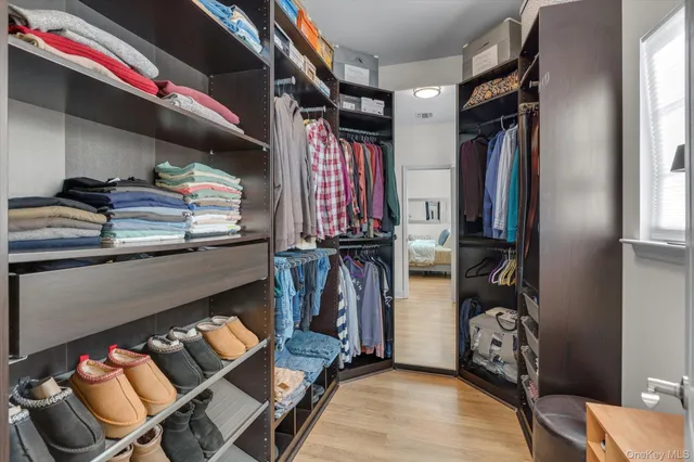 a view of walk in closet with clothes and shoes
