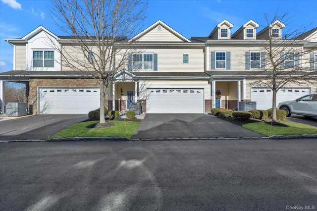 a view of a white house with large windows next to a road