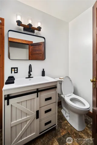 a bathroom with a toilet a sink and mirror