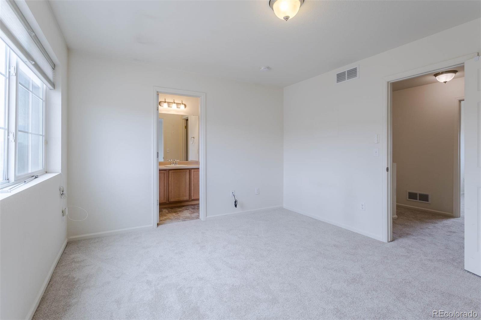 5559 Malta Street Denver, CO 80249 - Photo 15 of 27 an empty room with closet and windows