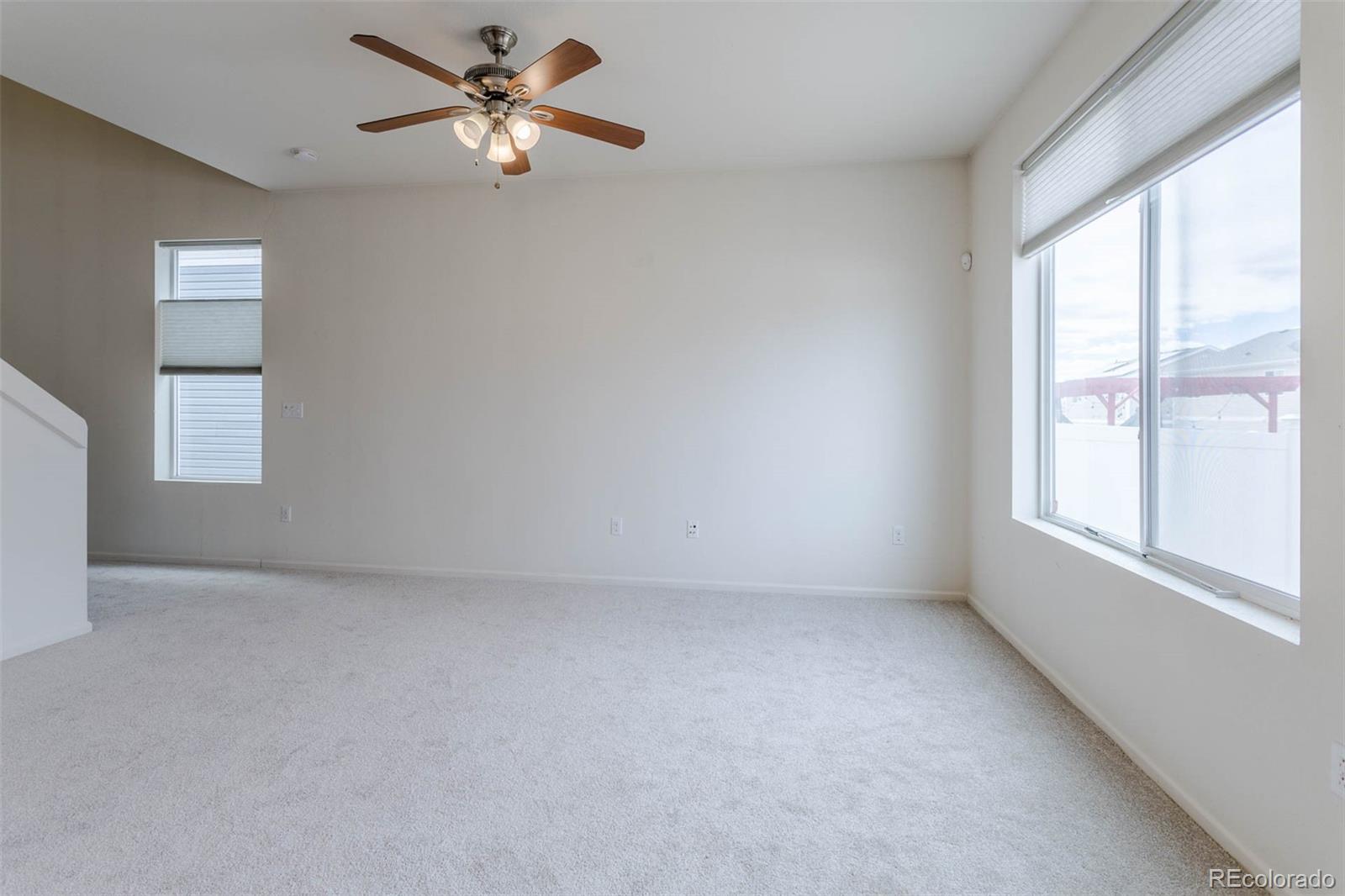 5559 Malta Street Denver, CO 80249 - Photo 5 of 27 an empty room with windows and fan
