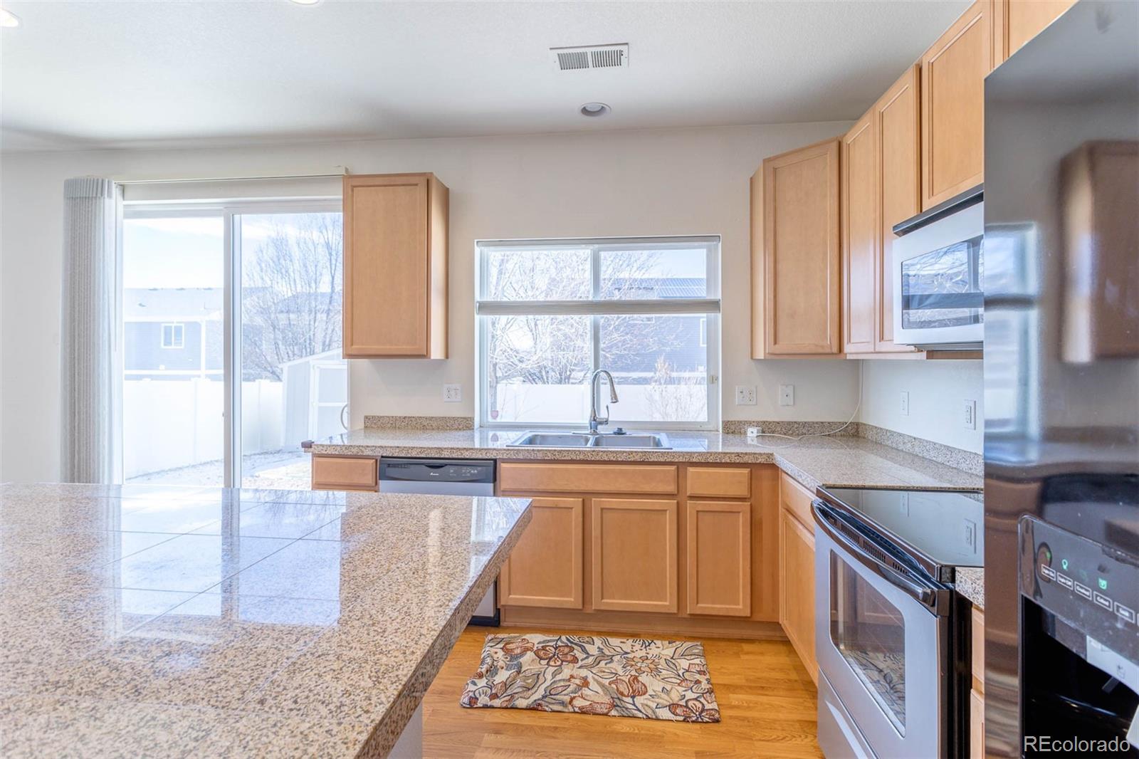 5559 Malta Street Denver, CO 80249 - Photo 6 of 27 a kitchen with a sink stove and cabinets