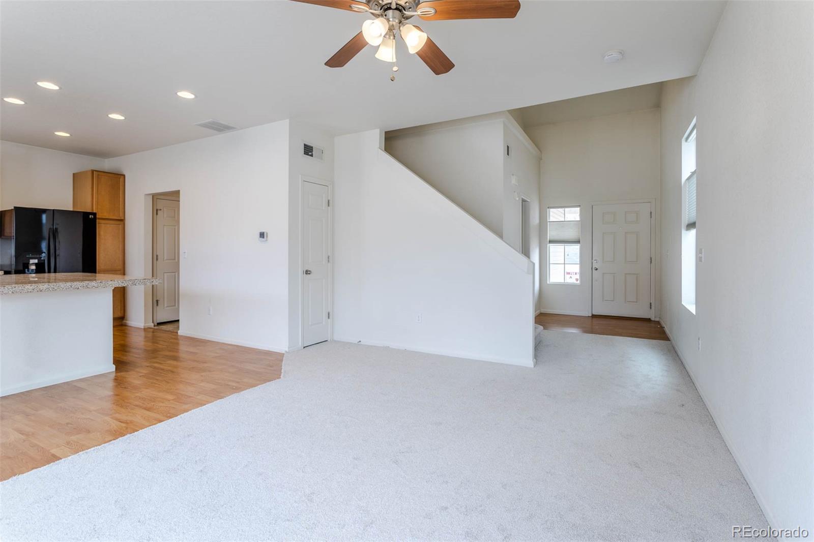 5559 Malta Street Denver, CO 80249 - Photo 8 of 27 a view of a livingroom with kitchen and an empty room