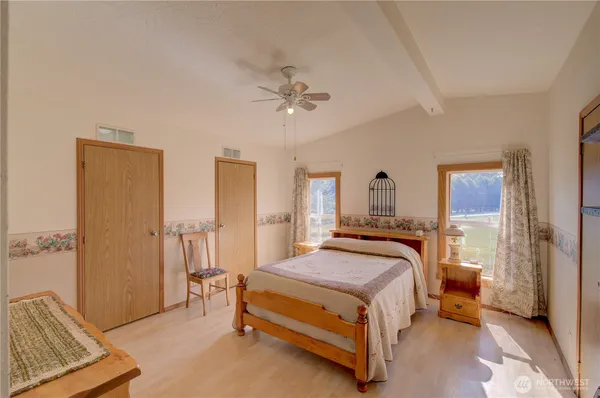 a bedroom with a bed and wooden floor