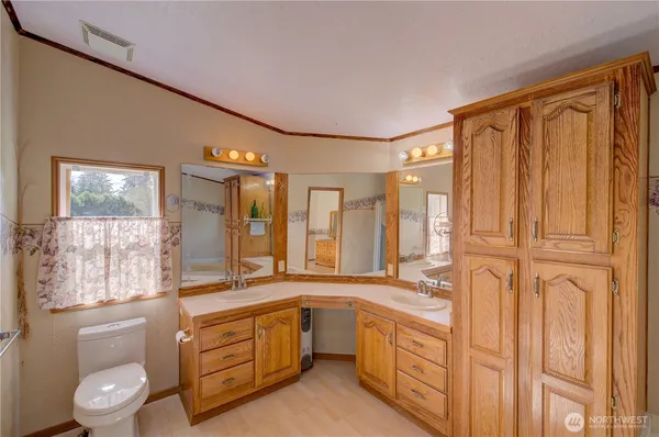 a spacious bathroom with a double vanity sink a large mirror and a shower