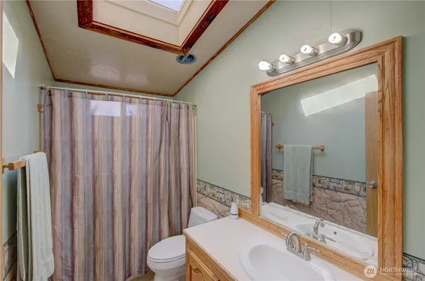 a bathroom with a sink vanity mirror and toilet
