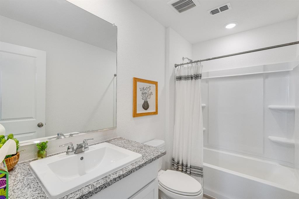 1413 Grove Pond Road Forney, TX 75126 - Photo 17 of 22 a bathroom with a granite countertop sink toilet a mirror and shower