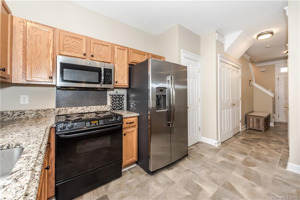 249 Faust Road Davidson, NC 28036 - Photo 19 of 36 a kitchen with granite countertop a stove microwave and refrigerator
