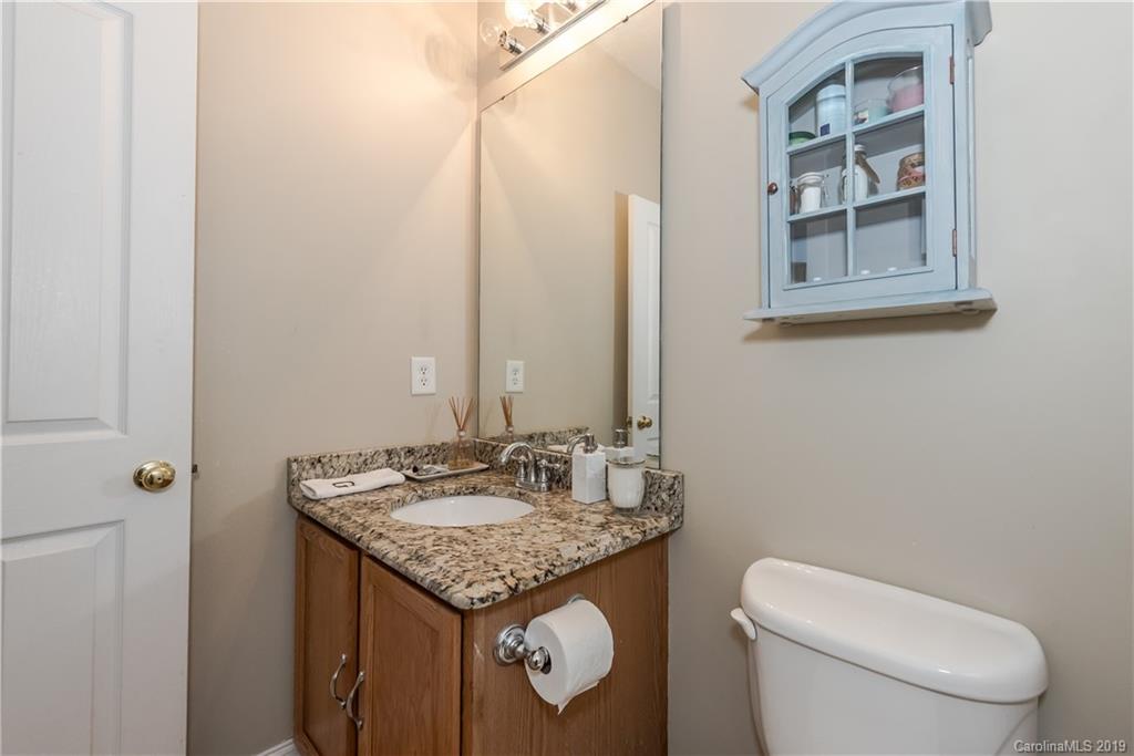 249 Faust Road Davidson, NC 28036 - Photo 23 of 36 a bathroom with a granite countertop toilet a sink and a mirror