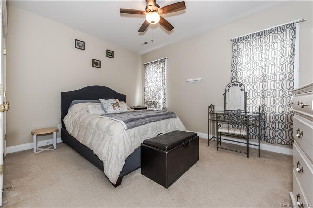 249 Faust Road Davidson, NC 28036 - Photo 27 of 36 a bedroom with a bed and a chandelier