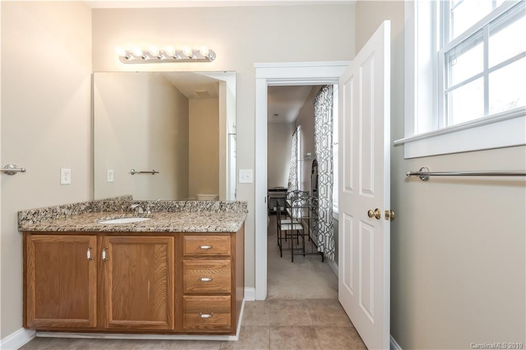 249 Faust Road Davidson, NC 28036 - Photo 29 of 36 a bathroom with a granite countertop sink a mirror and a vanity