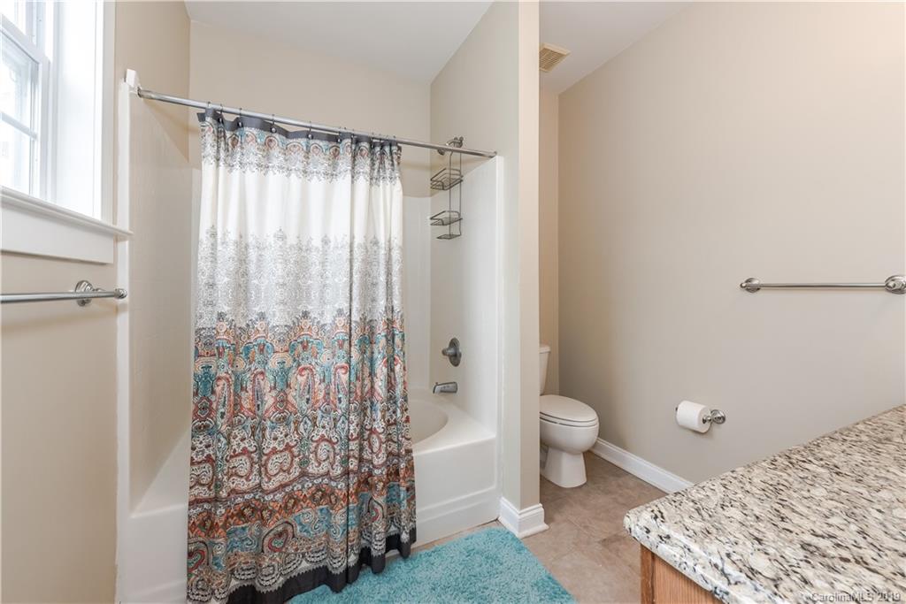 249 Faust Road Davidson, NC 28036 - Photo 30 of 36 a bathroom with a granite countertop shower a toilet and a shower