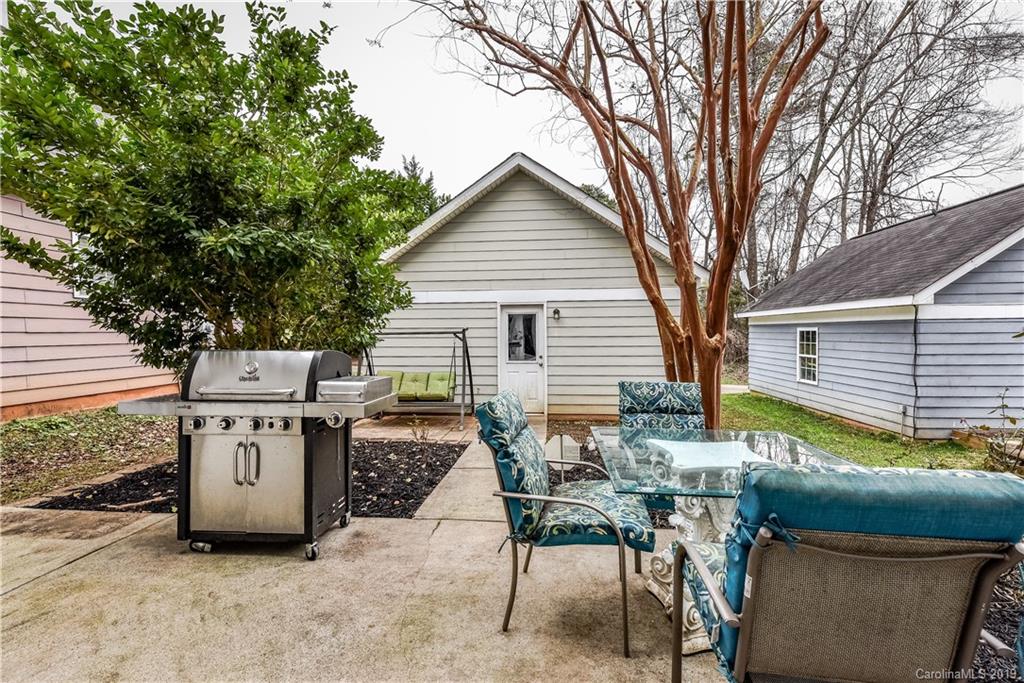 249 Faust Road Davidson, NC 28036 - Photo 31 of 36 a view of a patio with table and chairs and a barbeque with potted plants and large trees