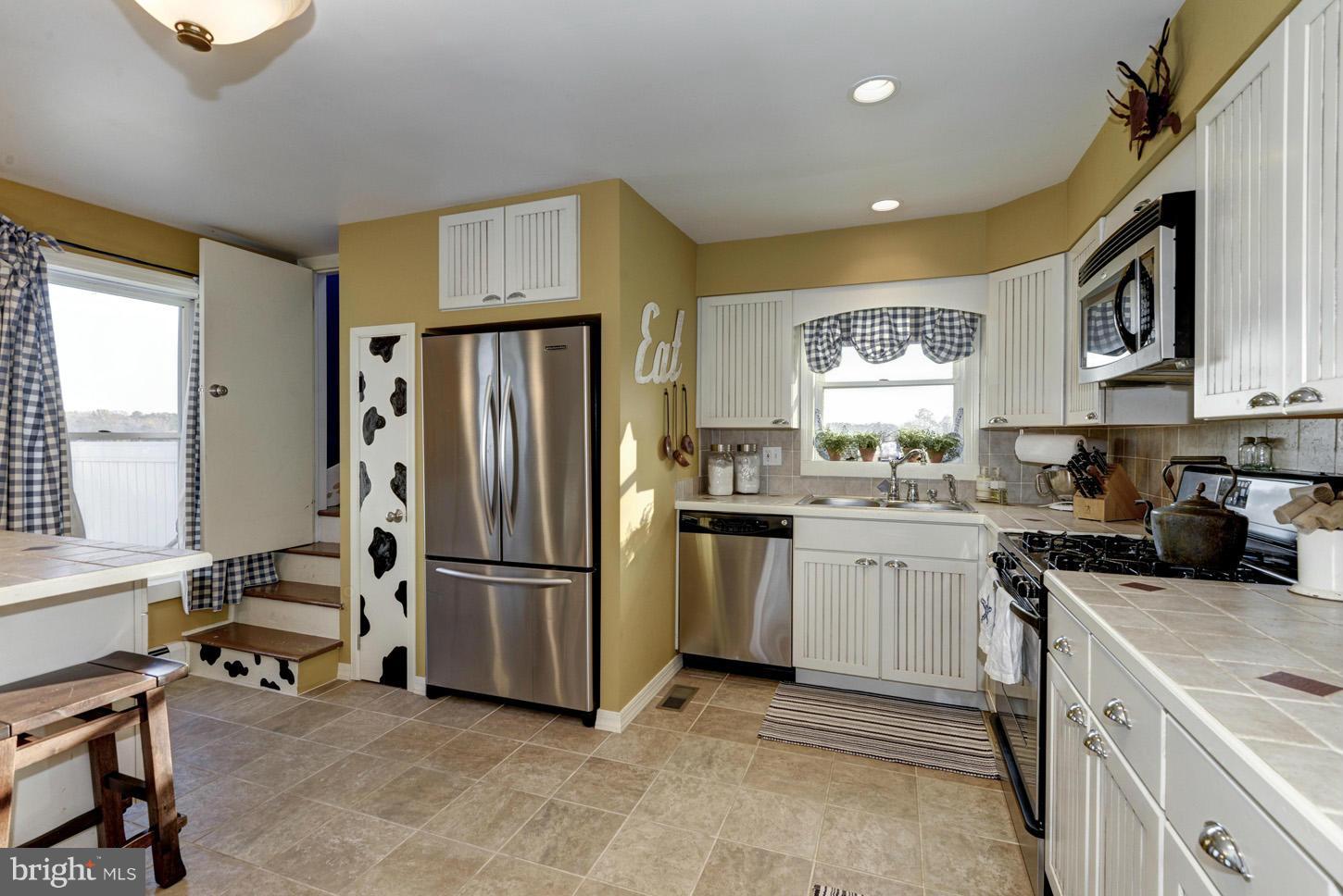 4940 Skinners Neck Road Rock Hall, MD 21661 - Photo 14 of 30 a kitchen with a refrigerator and a sink