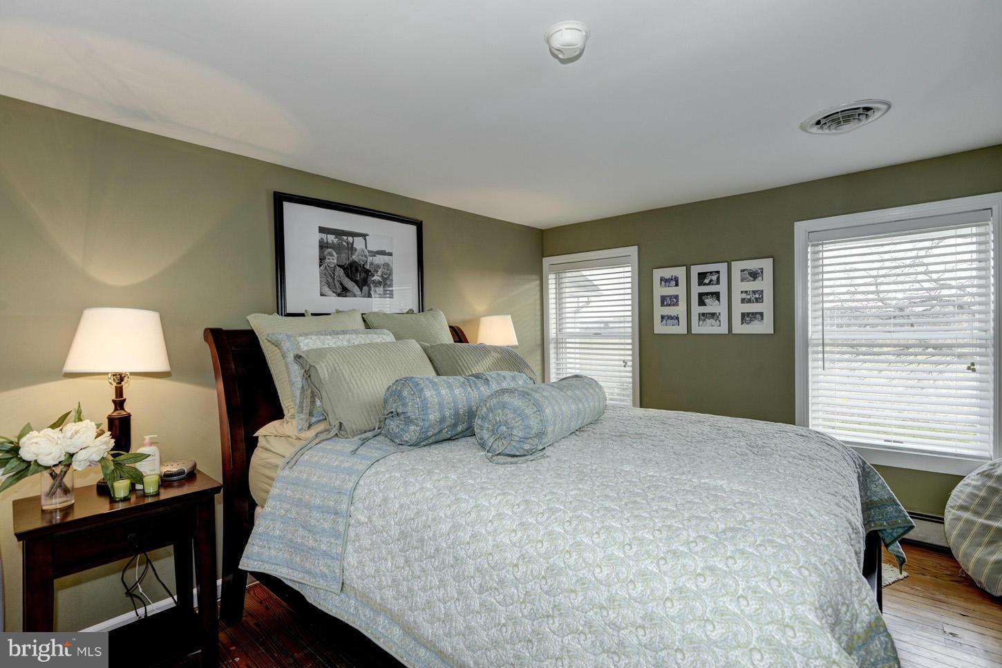 4940 Skinners Neck Road Rock Hall, MD 21661 - Photo 15 of 30 a bedroom with a bed and a lamp on table