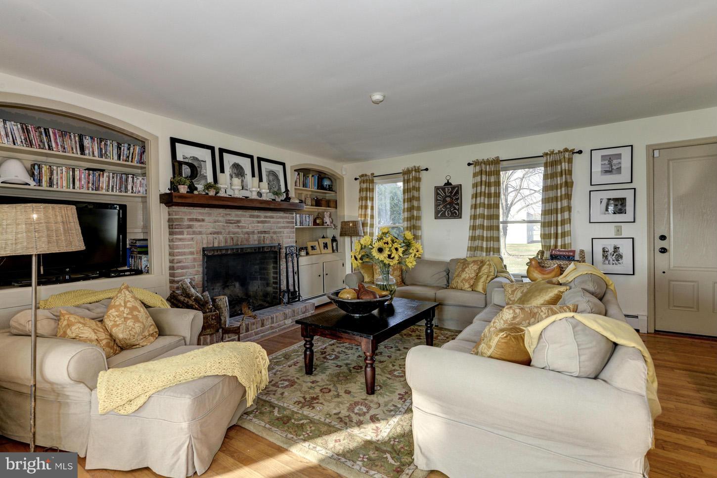 4940 Skinners Neck Road Rock Hall, MD 21661 - Photo 6 of 30 a living room with furniture a flat screen tv and a fireplace
