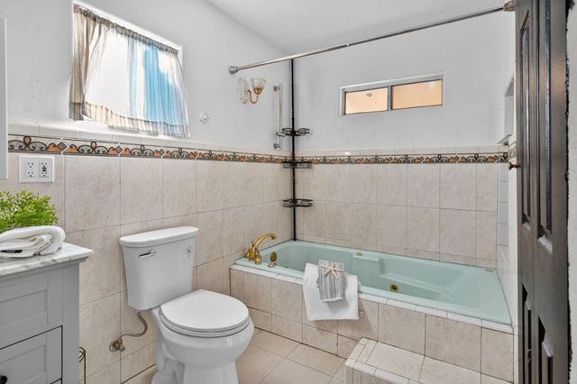 a bathroom with a granite countertop toilet a sink and bathtub