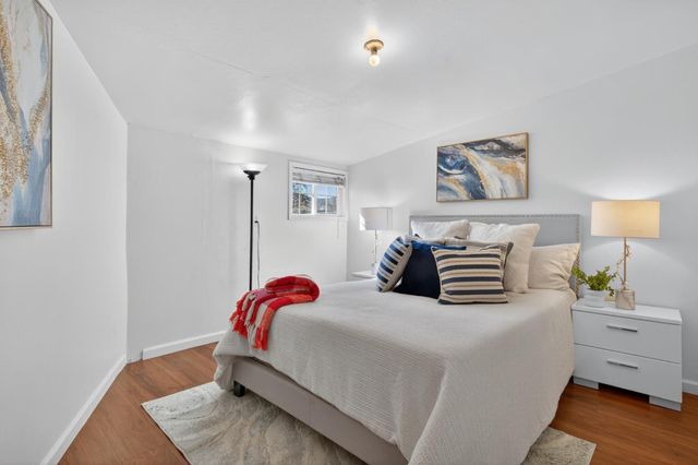 a bedroom with a bed and a lamp on dresser