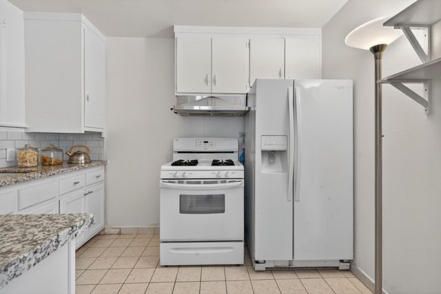 a kitchen with cabinets and white appliances