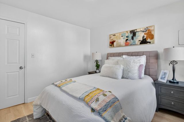 a bedroom with a bed and wooden floor