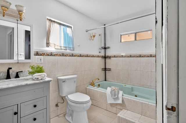 a bathroom with a granite countertop sink a toilet and shower