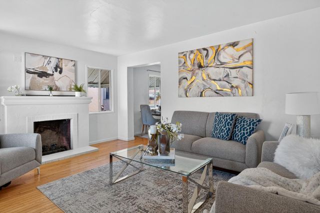 a living room with furniture a fireplace and a painting on the wall